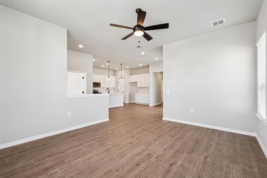 Unfurnished living room with ceiling fan, wood fi
