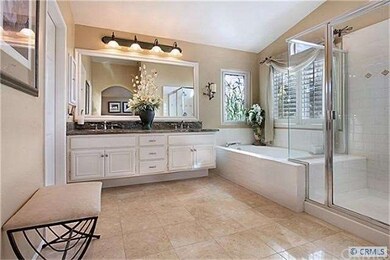 Master bath features gleaming Travertine tile, dua