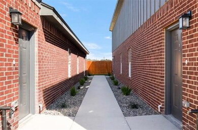 View of property exterior with brick siding, fence, and board and batten siding