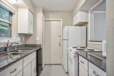 Kitchen with white cabinets, white electric stove,