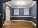 Unfurnished dining area with arched walkways, wood finished floors, a chandelier, and baseboards