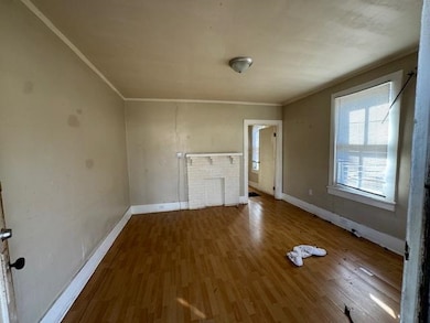 Unfurnished living room with hardwood / wood-style flooring and ornamental molding