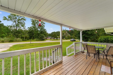 Wooden deck featuring a yard, view of wooded area, and outdoor dining space