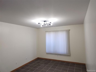 Bedroom with dark tile patterned flooring and a chandelier