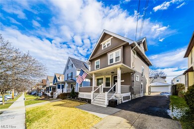 View of front of house with a front yard, a garage, and a porch