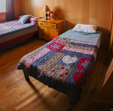 Bedroom with wood finished floors and wooden walls