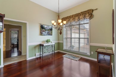 Dining room with dark wood-type flooring and a chandelier