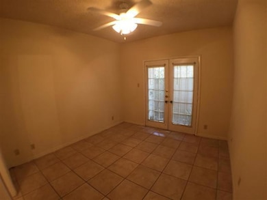 Empty room featuring french doors, ceiling fan, a