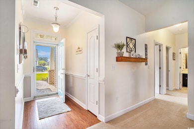 Entryway with ornamental molding, baseboards, and wood finished floors