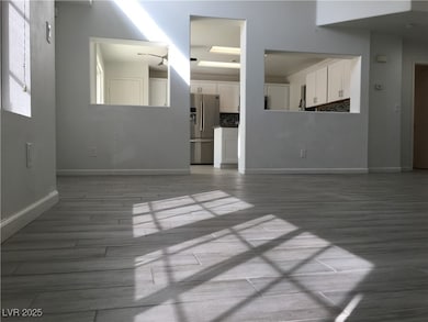 Unfurnished living room with baseboards and light wood-style floors