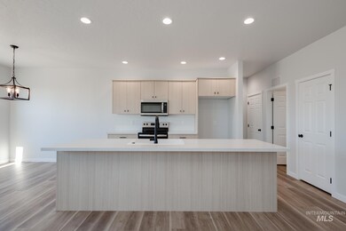 Kitchen with recessed lighting, light wood-style floors, a kitchen island with sink, stainless steel appliances, and light brown cabinetry