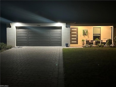 View of front facade featuring decorative driveway, stucco siding, and a garage