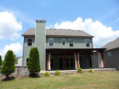 Rear view of property featuring a ceiling fan, a yard, a patio, and a chimney