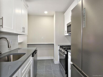 Kitchen with appliances with stainless steel finishes, decorative backsplash, white cabinetry, recessed lighting, and dark stone counters