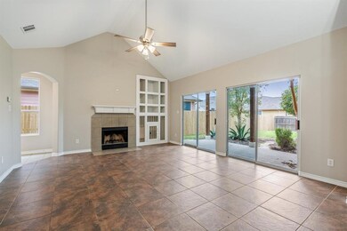 Living room features tile floors, vaulted ceilings and ceiling fan.