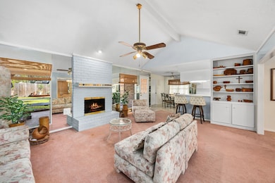 Expansive family room featuring a cozy wood-burning fireplace and elegant custom shelving.