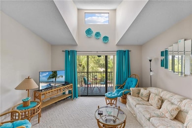 Carpeted living area with a towering ceiling and plenty of natural light - only 3rd floor units offer a skylight