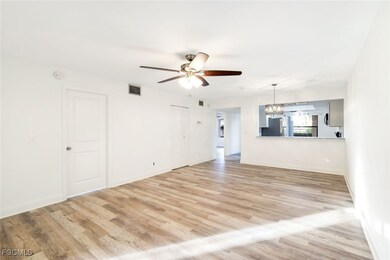 Unfurnished living room with a chandelier, light wood-style floors, and ceiling fan