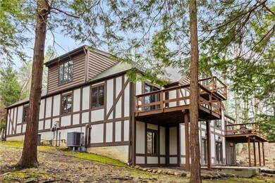 Back of property featuring a wooden deck, stucco siding, and roof with shingles