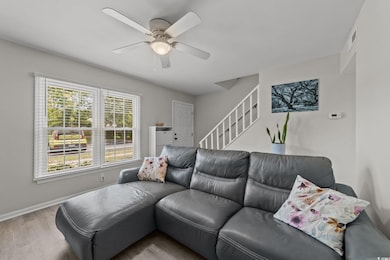 Living room featuring wood finished floors, stairway, ceiling fan, and baseboards