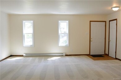 View of living room facing the front of house (front door and coat closet to the right).