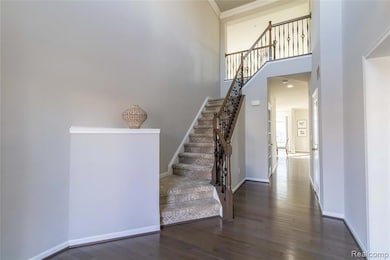 Stairs with wood finished floors, a towering ceiling, and recessed lighting