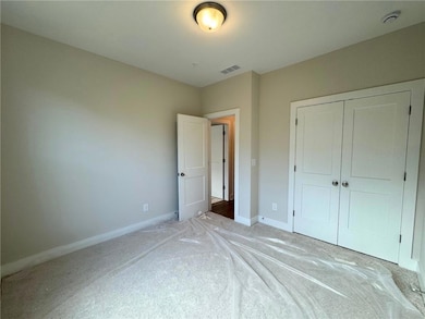 Unfurnished bedroom featuring carpet and a closet