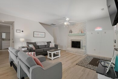 Living area featuring a ceiling fan, a brick firep