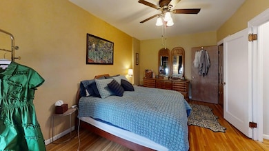 Bedroom featuring baseboards, ceiling fan, and wood finished floors