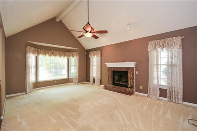 Unfurnished living room with a brick fireplace, ba