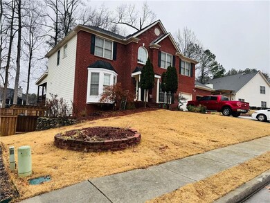 View of front facade with brick siding and an attached garage