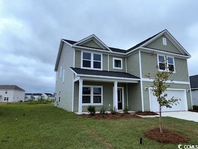 View of front facade featuring covered porch, a ga