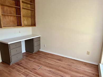 Unfurnished office featuring built in study area and light wood-style flooring