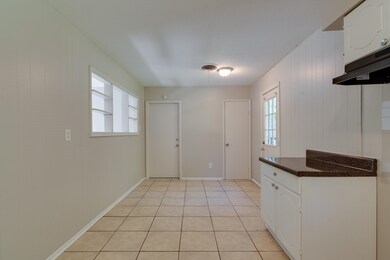 Kitchen with light tile patterned floors and white
