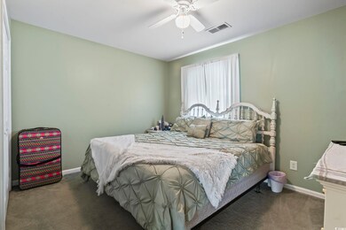 Carpeted bedroom featuring baseboards and a ceiling fan