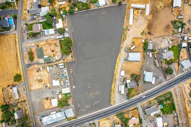 Aerial view of property and surrounding area with nearby suburban area