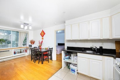 Kitchen featuring light wood finished floors, white range, open shelves, and white cabinets