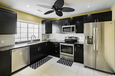 Kitchen featuring a sink, tasteful backsplash, app