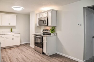 The kitchen has white cabinets and new counters.