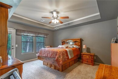 Spacious master bedroom with tray ceiling, door to