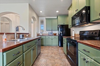 Kitchen featuring green cabinets, black appliances, recessed lighting, and dark countertops