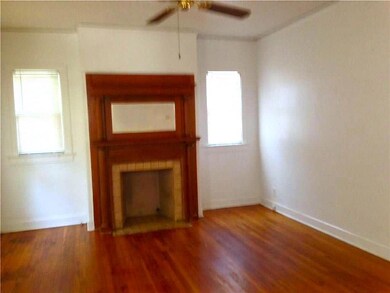 Unfurnished living room with wood finished floors and a ceiling fan