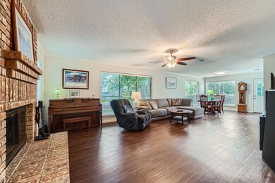 Living area with a fireplace, ceiling fan, a text