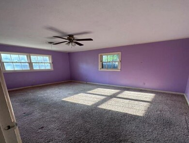 Carpeted empty room featuring ceiling fan