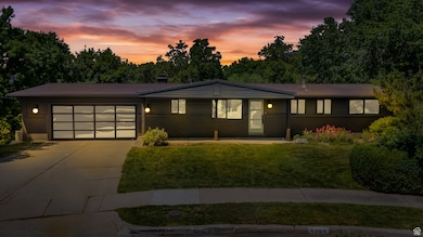 View of front facade with driveway, a front lawn, a garage, and covered porch
