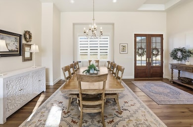 Dining area with plenty of natural light, dark wood-type flooring, a chandelier, and recessed lighting