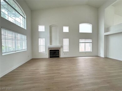 Unfurnished living room featuring light wood-style flooring, a tiled fireplace, and a high ceiling