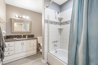 Full bathroom with shower / tub combo and vanity