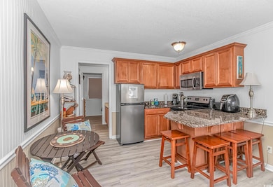 Kitchen with brown cabinets, appliances with stain