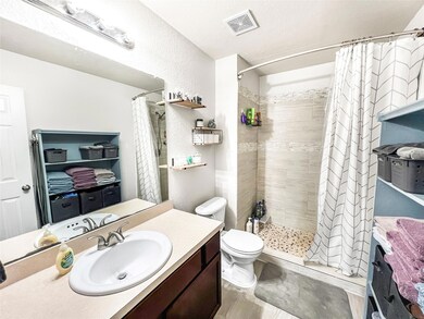 Full bathroom with vanity, a tile shower, toilet,